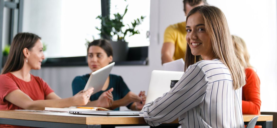 Young businesswoman looking at camera over the shoulder and smiling